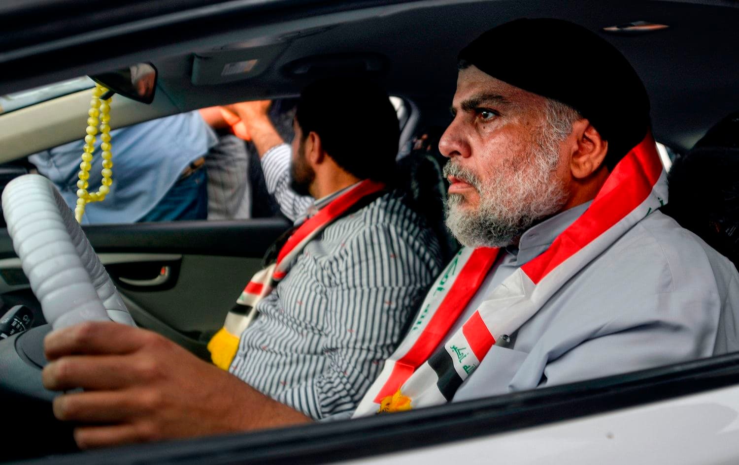  Iraqi Shiite cleric Moqtada al-Sadr (R) drives a car as he joins anti-government demonstrators gathering in the central holy city of Najaf on October 29, 2019. . Photo: AFP / STR