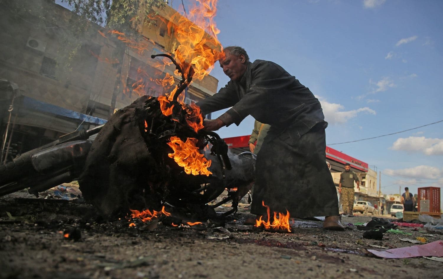 A Syrian man stands next to a burning motorcycle at the site of a car bomb explosion in the northern Syrian Kurdish town of Tal Abyad, on the border with Turkey, on November 2, 2019.Photo: Bakr Alkasem/AFP