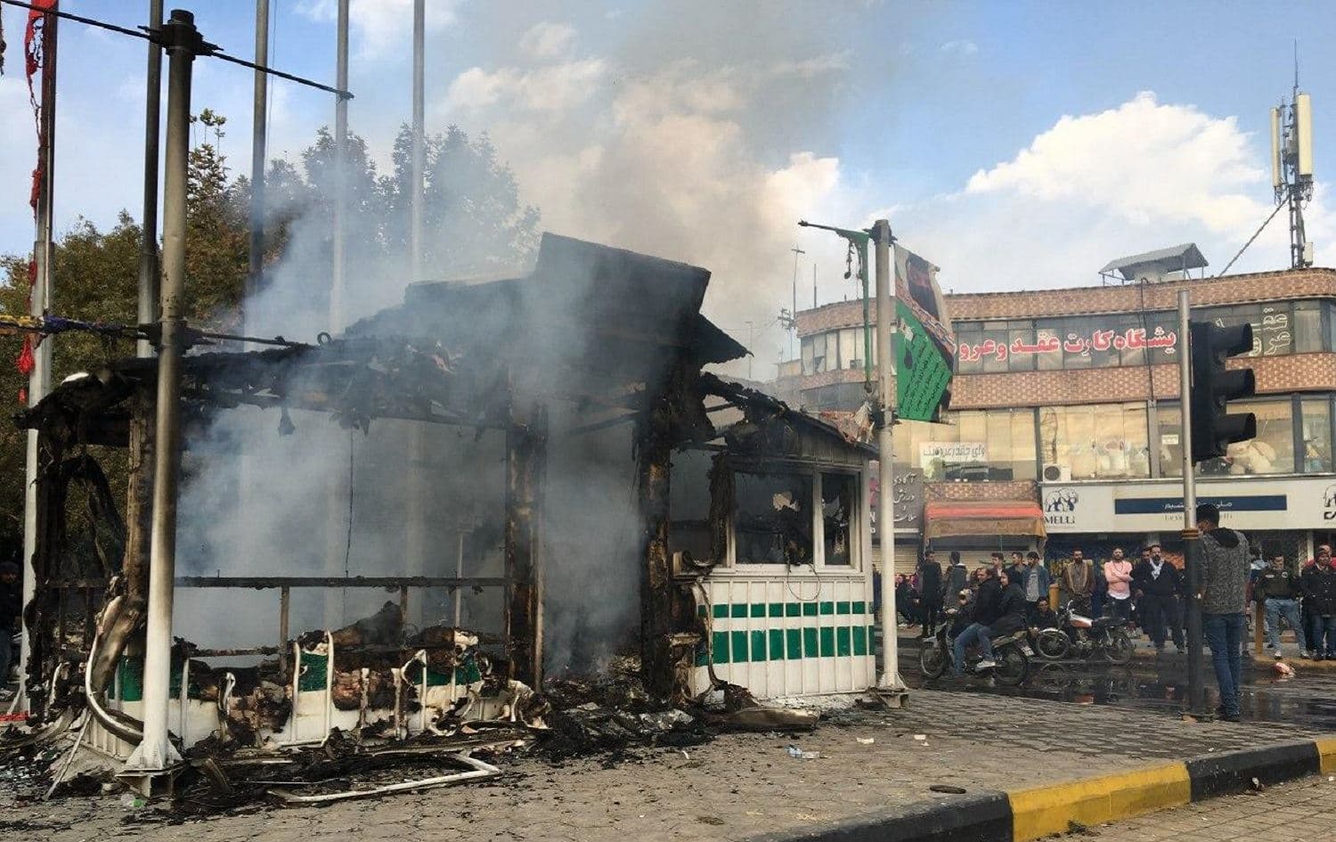 Iranians gather around a charred police station that was set ablaze by protesters during a demonstration against a rise in gasoline prices in the central city of Isfahan, November 17, 2019. Photo: AFP 