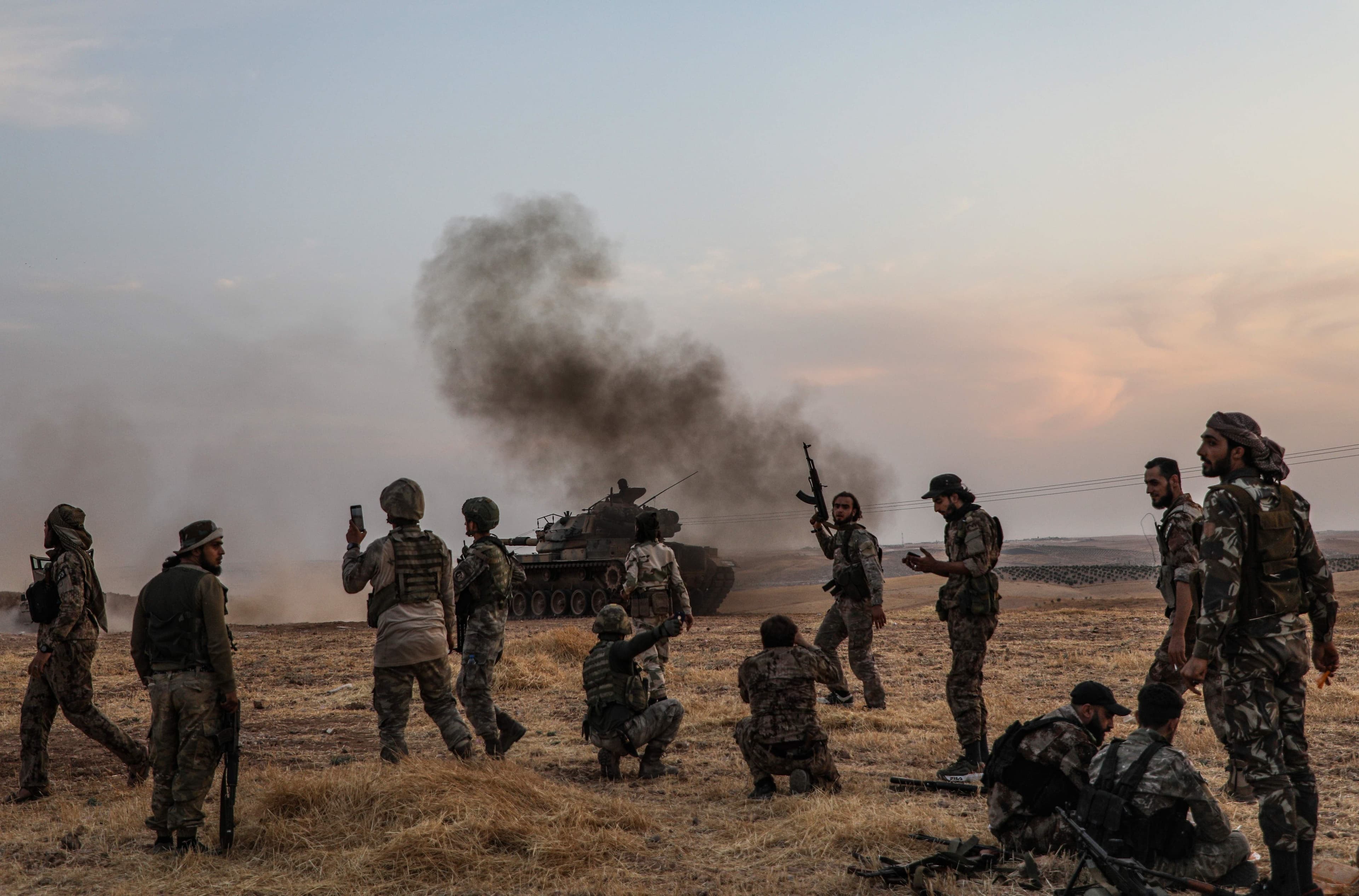 Turkish soldiers and Turkey-backed Syrian fighters gather on the northern outskirts of the Syrian city of Manbij near the Turkish border in October 2019. Photo: AFP / Zein al-Rifai