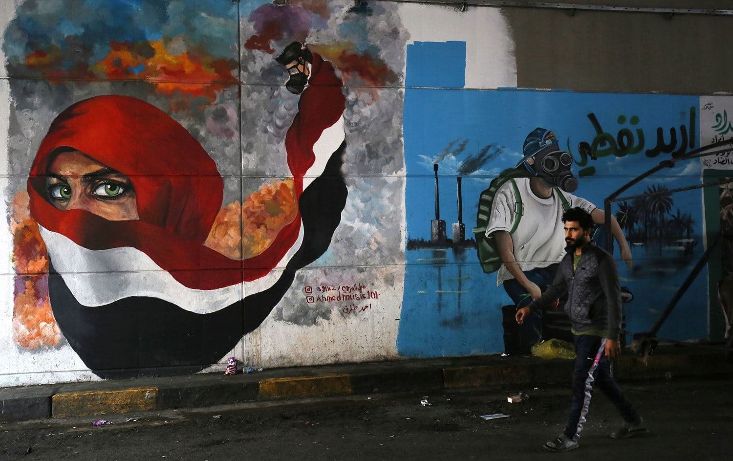 An Iraqi man walks past murals regarding ongoing anti-government demonstrations in Tahrir Square, Baghdad on December 13, 2019. Photo: AFP / Ahmad al-Rubaye