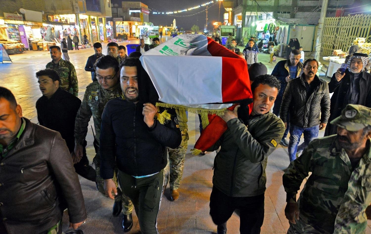  Mourners in Najaf, pictured on December 13, carry the coffin of a teenager who was killed and lynched in Baghdad the day before. Photo: Haidar Hamdani/AFP