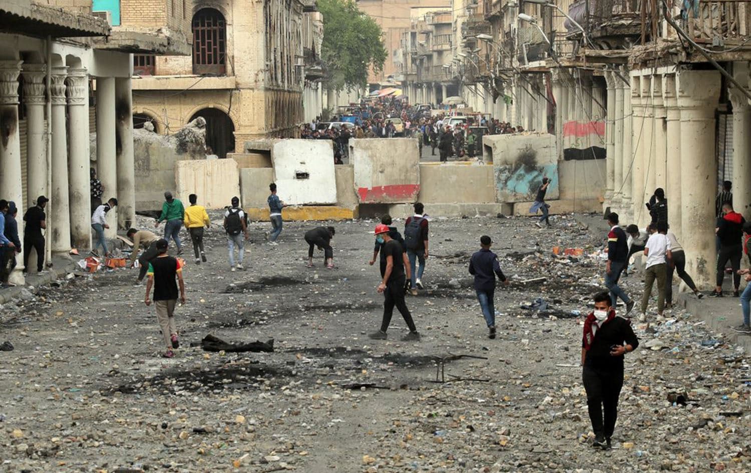 Anti-government protesters throw stones while security forces close Rasheed Street during clashes in Baghdad, Iraq on November 25, 2019. Photo: AP/Hadi Mizban