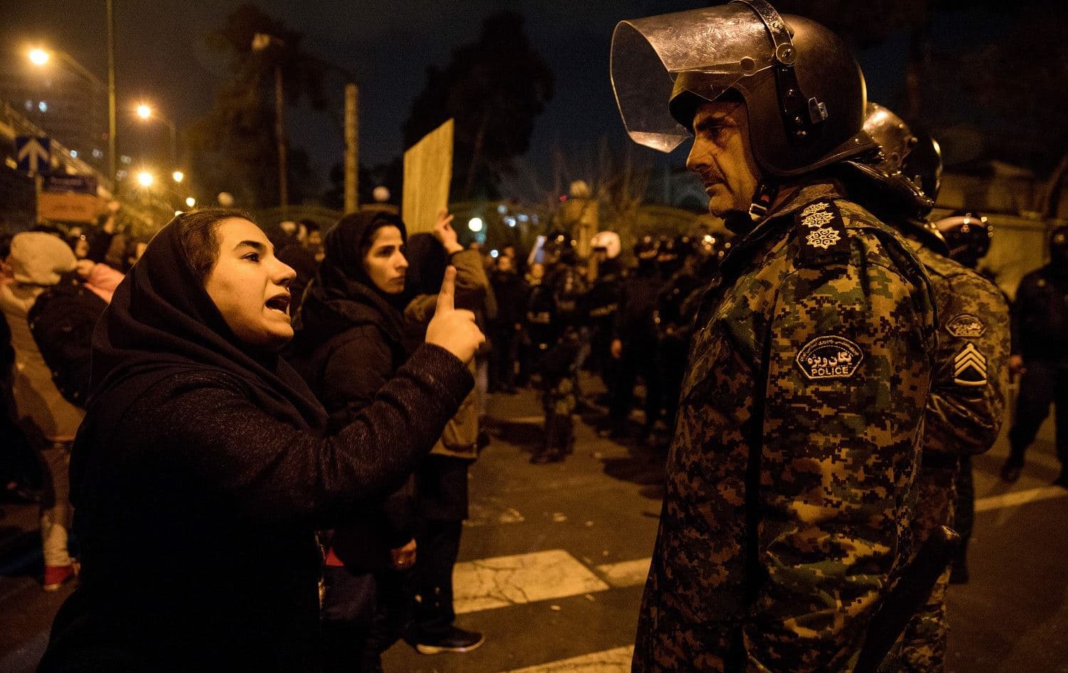 A woman confronts a policeman following a memorial vigil for the victims of Ukraine International Airlines Boeing 737 in front of Amirkabir University, Tehran on January 11, 2020. Photo: Mona Hoobehfekr / AFP