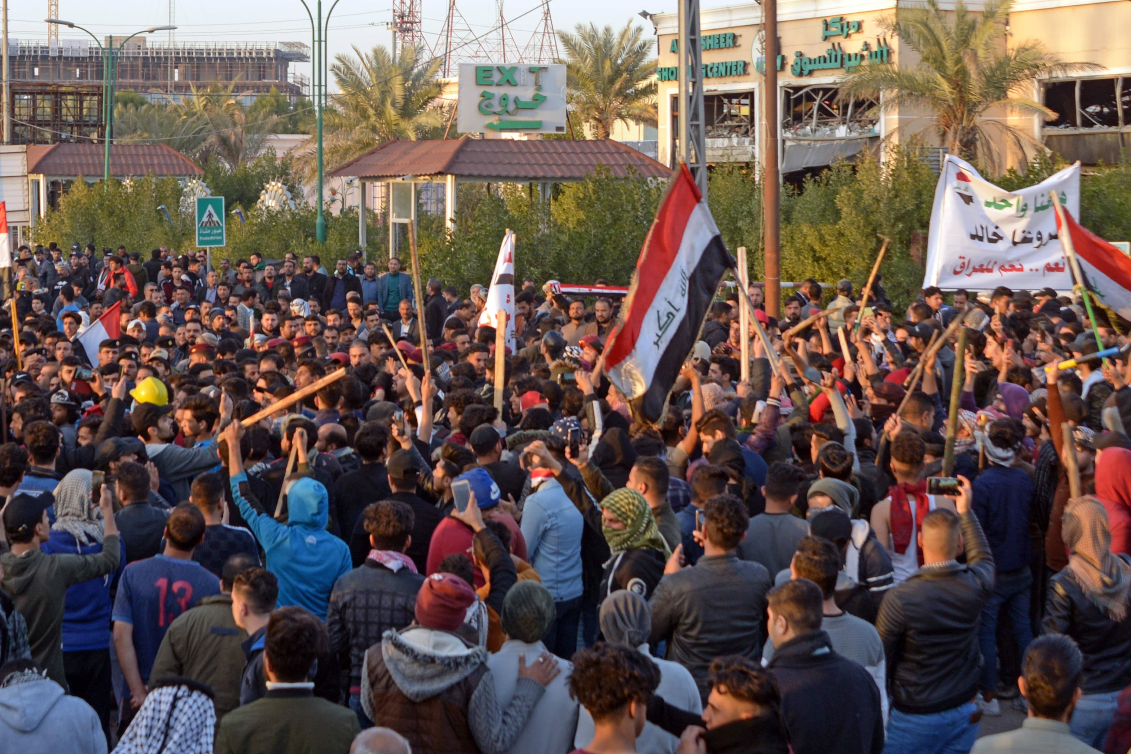 Iraqi followers of influential cleric Muqtada al-Sadr (with batons) clash with protesters as they raid an anti-government protest camp in the central holy city of Najaf on February 5, 2020. Photo: Haidar Hamdani / AFP