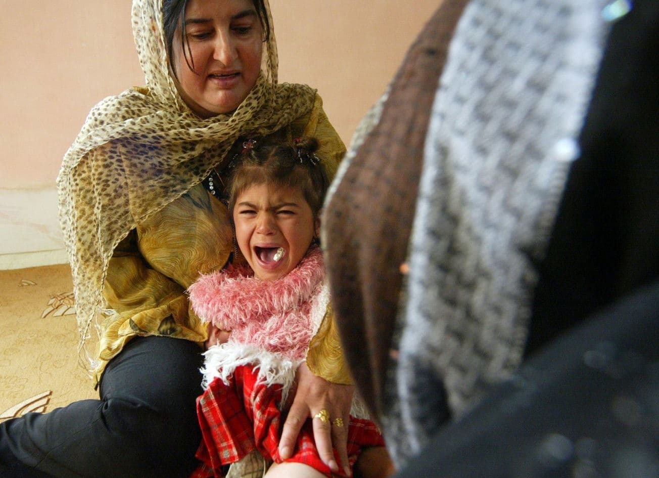 A four-year-old girl screams while being mutilated in Sulaimani province. File photo: AFP