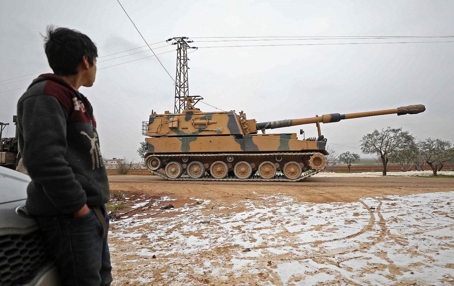 A child gazes at a Turkish 155mm self-propelled artillery gun in the town of Binnish in Syria’s northwestern province of Idlib, near the Syria-Turkey border, February 12, 2020. Photo: Omar Haj Kadour / AFP 