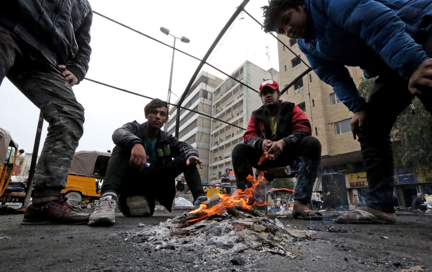  Iraqi protesters gather around a fire at al-Khilani square in the capital Baghdad on February 16, 2020 amid ongoing anti-government demonstrations. Photo via AFP / Sabah Arar
