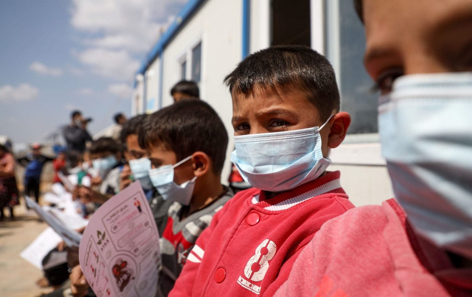 Displaced Syrian children and their parents attend a coronavirus awareness workshop  at a camp near the Syrian town of Atme, Idlib province on March 16, 2020. Photo: Aaref Watad / AFP