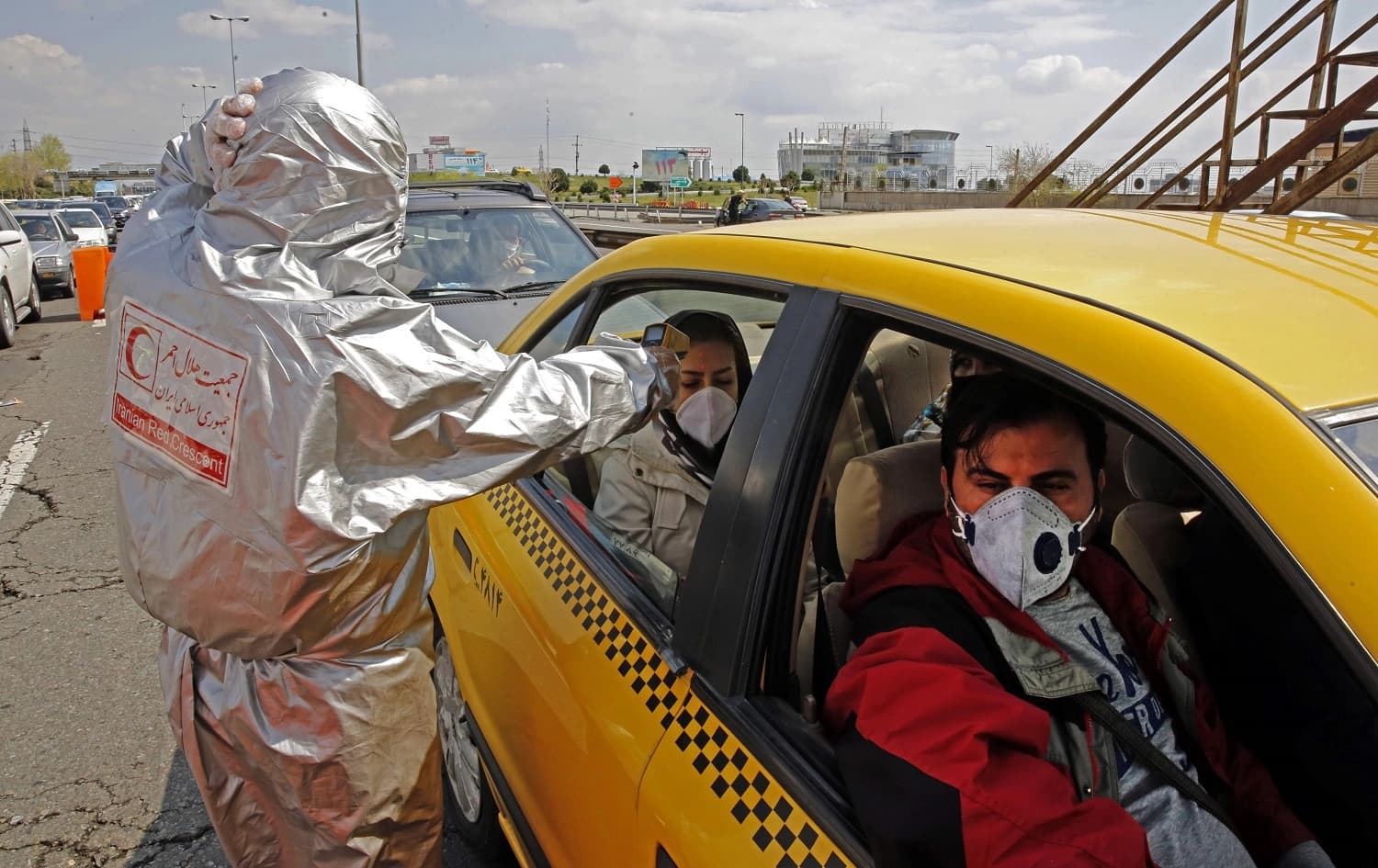 Members of Iranian Red Crescent test people for possible coronavirus COVID-19 symptoms in Tehran, March 26, 2020. Photo: STR / AFP