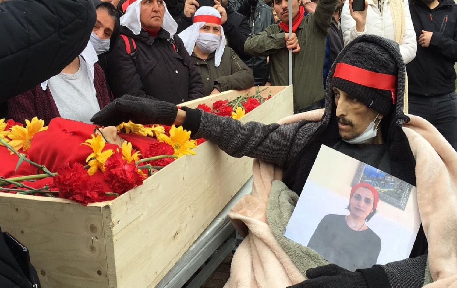 Ibrahim Gokcek sitting next to the body of Helin Bolek in Istanbul on April 3, 2020. Photo: Grup Yorum/Twitter