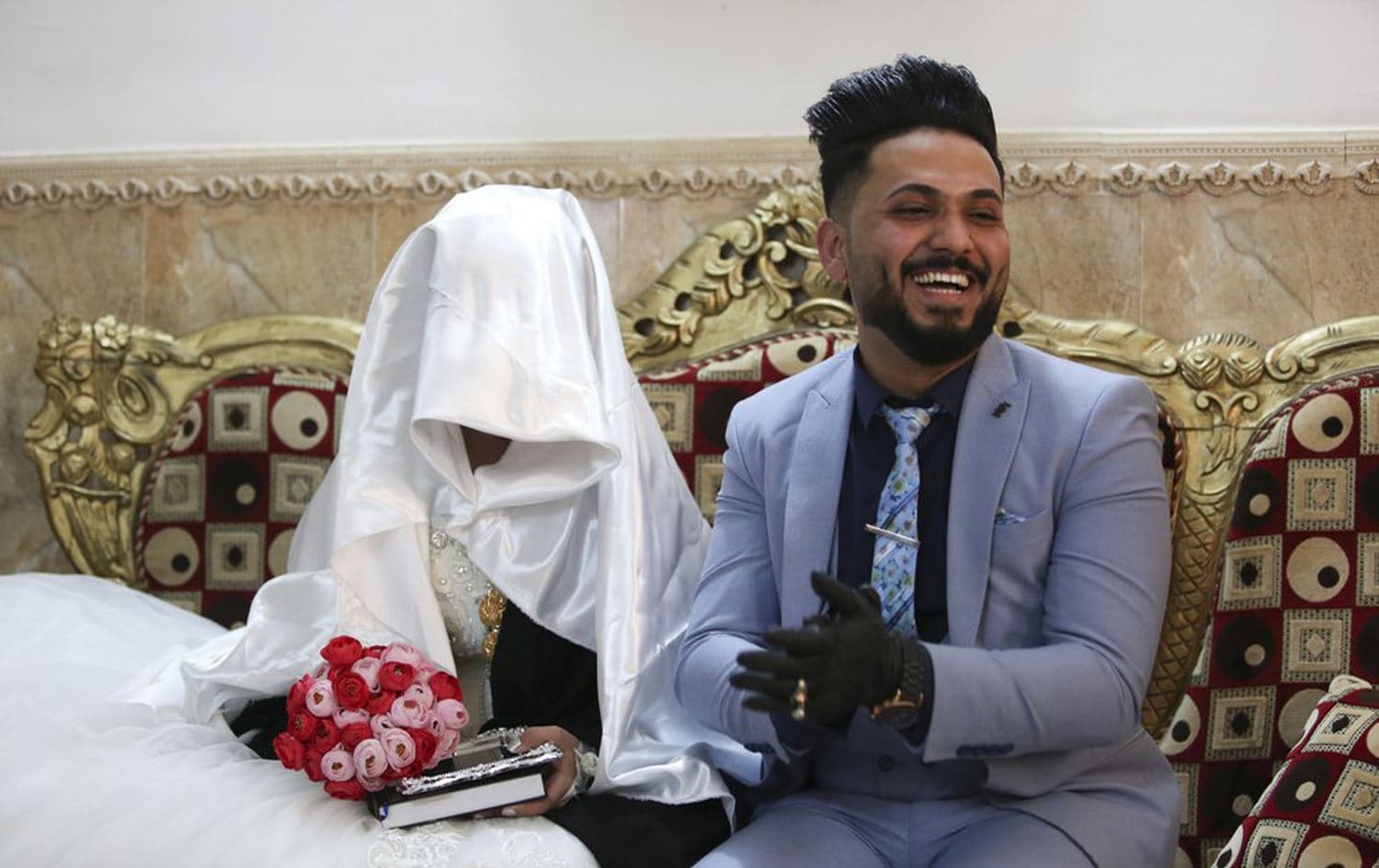 Ahmed Khaled al-Kaabi and his bride Ruqaya Rahim sit during their wedding in Najaf, Iraq, April 9, 2020. Photo: Anmar Khalil / AP