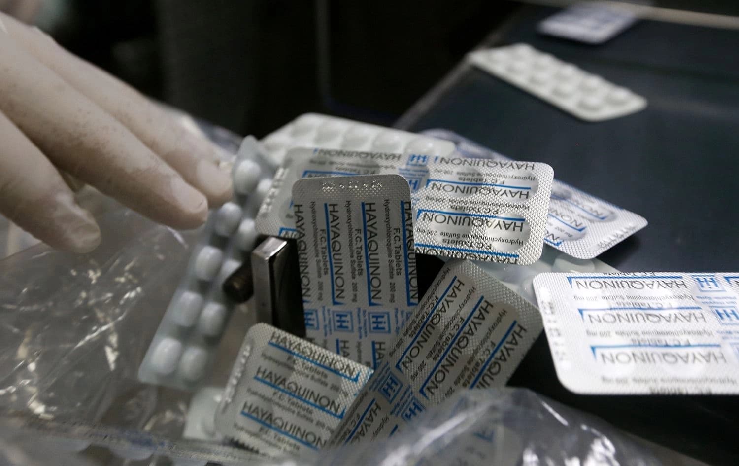 An employee of a Syrian pharmaceutical factory in Homs shows packs of the hydroxychloroquine drug, used in Syria to prevent or cure COVID-19, April 28, 2020. Photo: Louai Beshara / AFP 