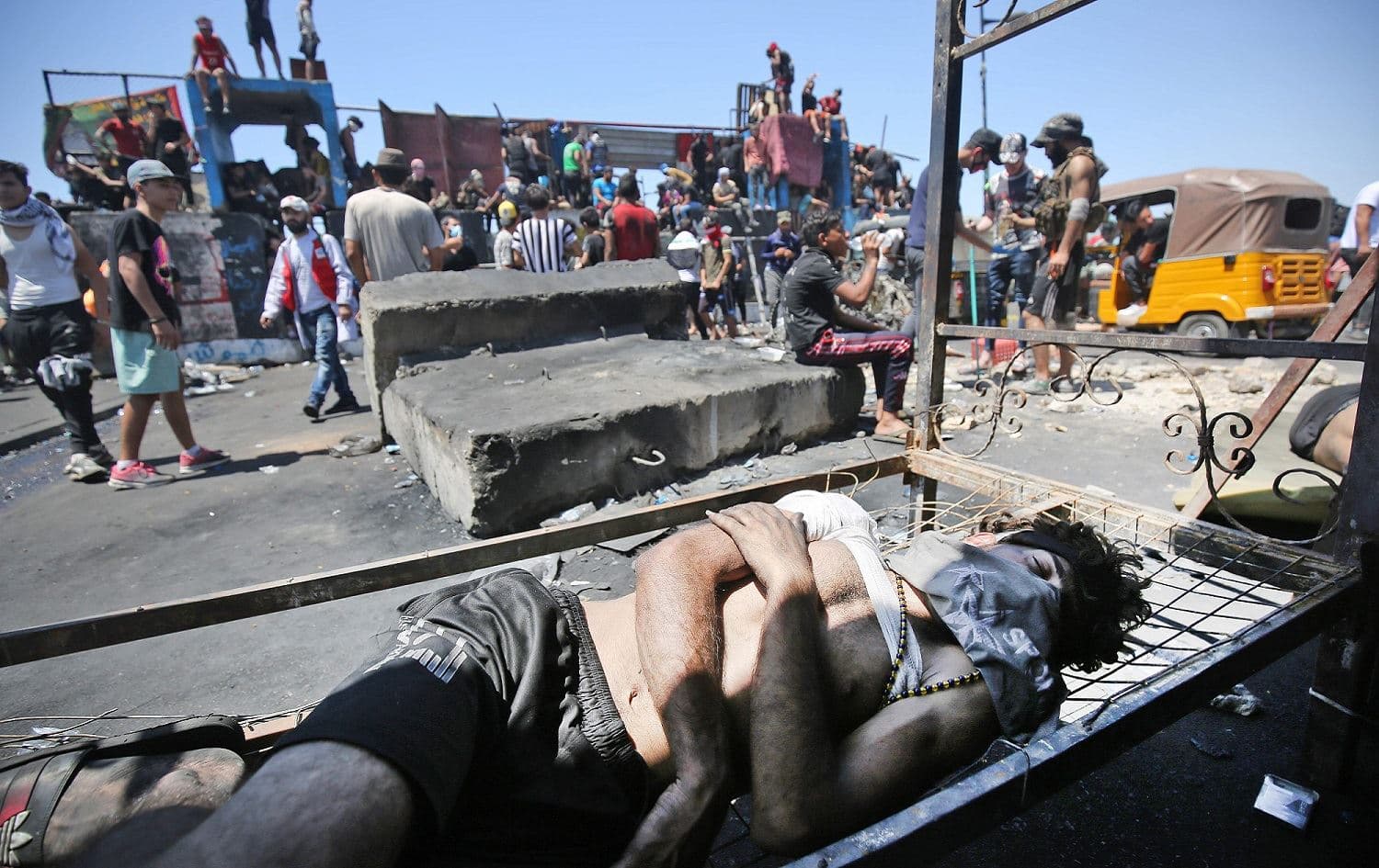 A wounded Iraqi protester rests on the Al-Jumhuriyah bridge in Baghdad, May 11, 2020. Photo: Ahmad al-Rubaye / AFP
