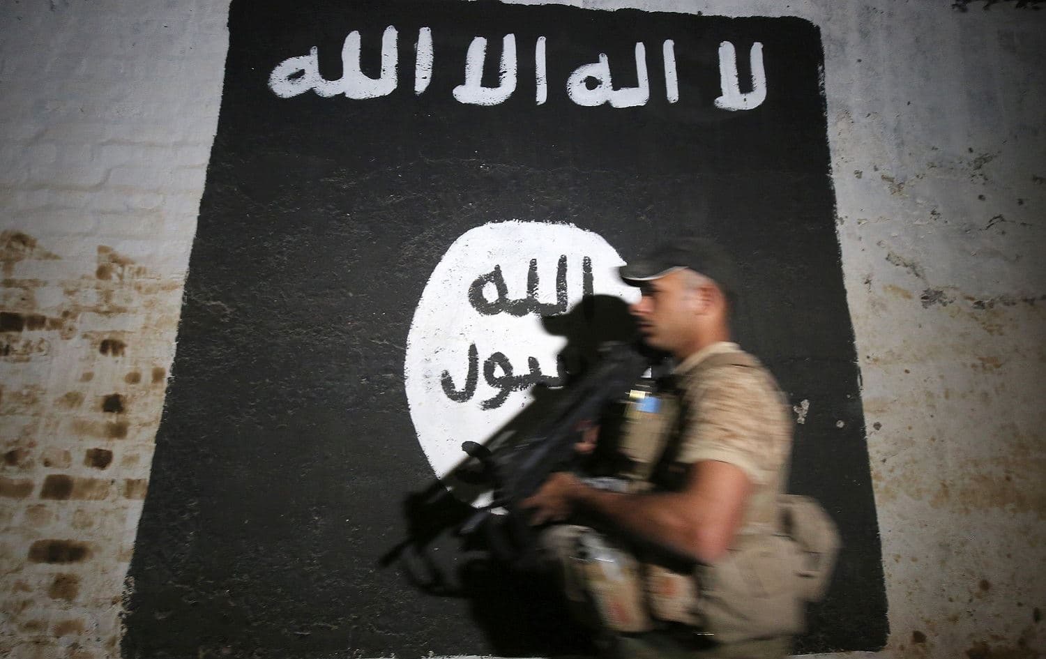 An Iraqi soldier walks past a mural bearing the logo of the Islamic State group in Albu Sayf, near Mosul, March 1, 2017. File photo: Ahmad al-Rubaye / AFP 