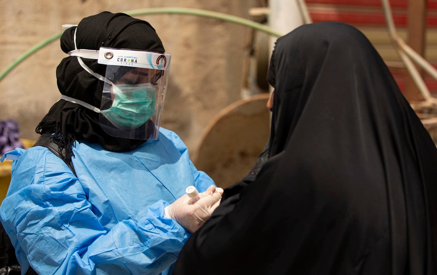 A medical worker prepares to take a swab from a woman being tested for COVID-19 in Basra on June 2, 2020. Photo: Hussein Faleh/AFP
