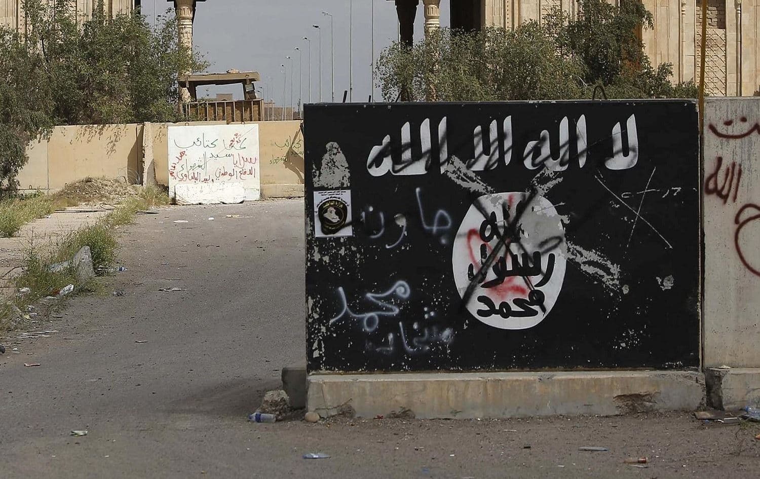A defaced Islamic State flag emblazoned on a wall in Tikrit, Iraq in 2015. File photo: Mohammed Sawaf/AFP