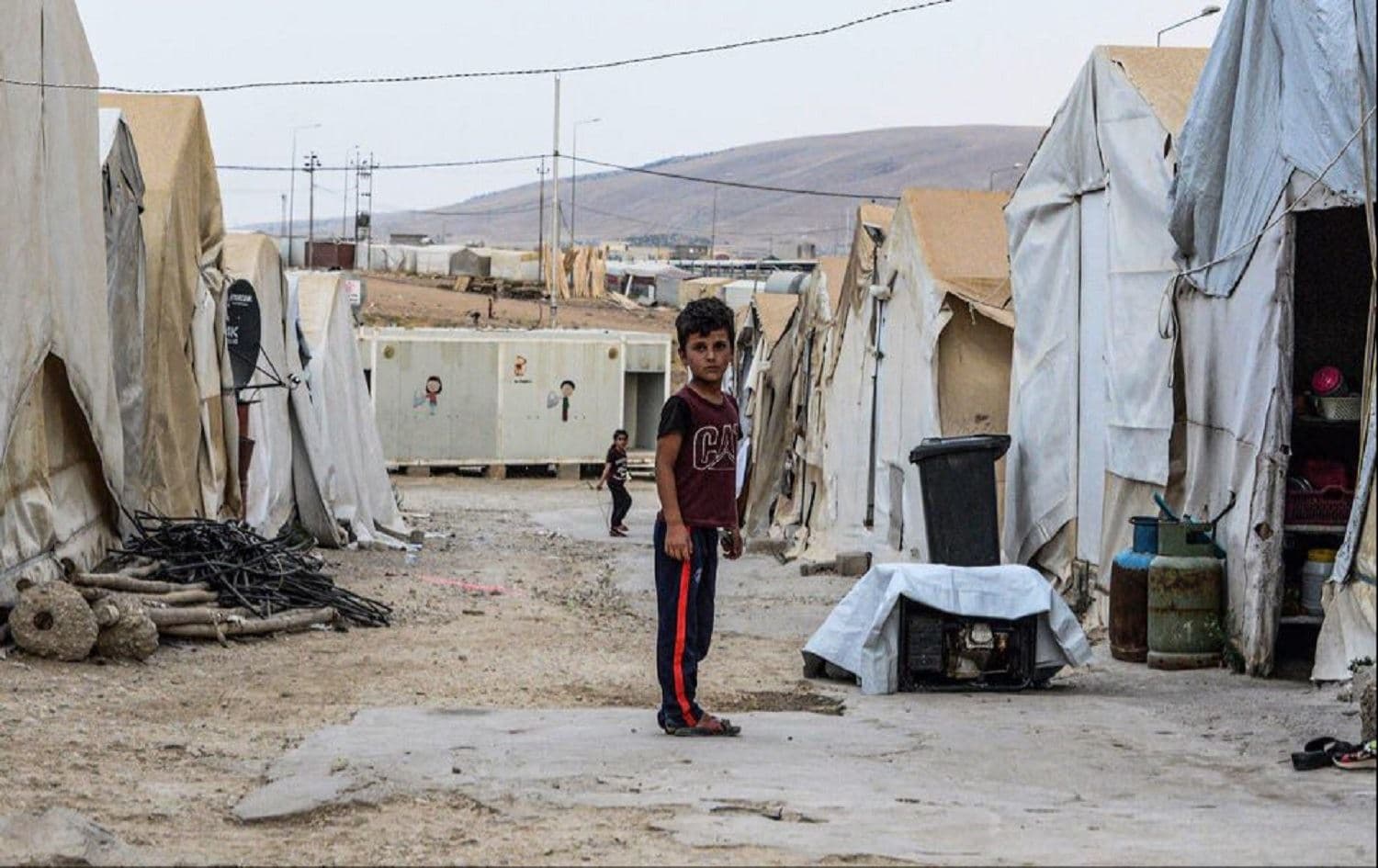 A boy stands between tents at a camp for internally displaced Yezidis near Dohuk on August 30, 2019. Photo: Zaid al-Obeidi / AFP