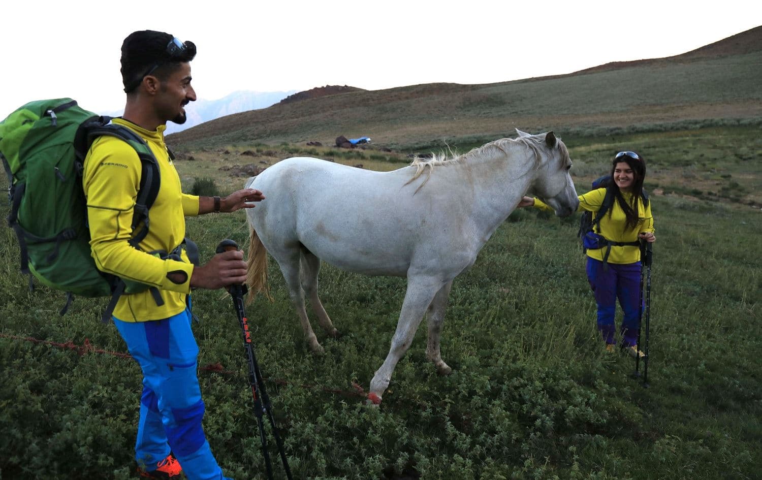 Newlyweds Iraqi Kurds Salar Chomany, 34, and Soma Mohammed, 28, pet a horse during a trekking ceremony at Mount Halgurd, in the Kurdistan Region of Iraq, on the first day of their honeymoon, on August 2, 2020. Photo: Safin Hamed / AFP