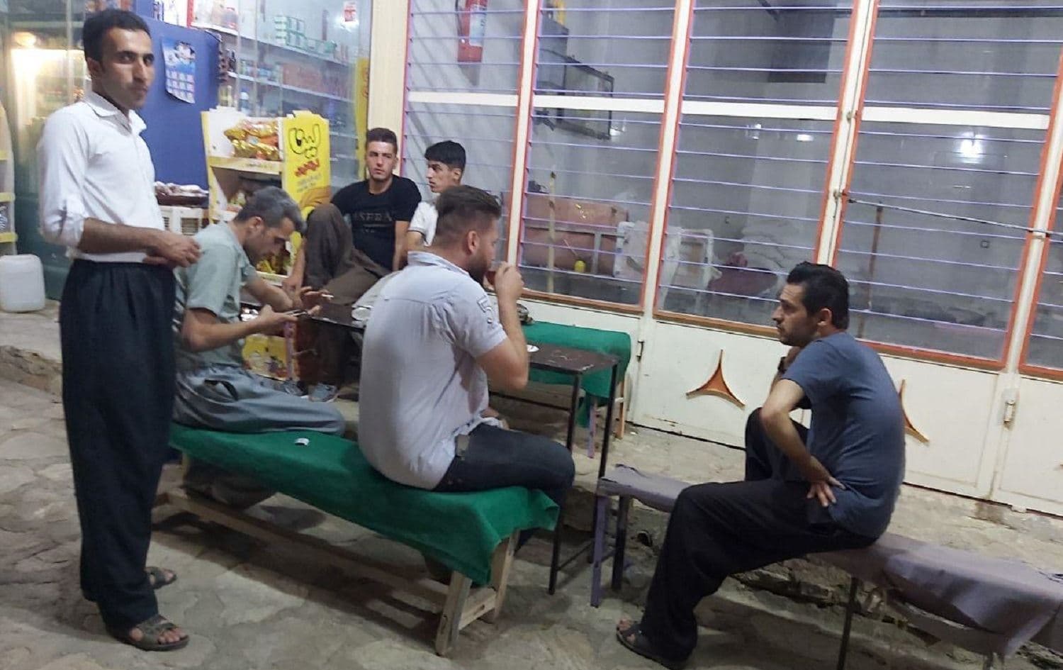 Barzan Qadiri (center, drinking tea) and his friends discuss leaving their home village of Dizli, Hawraman for Europe on August 8, 2020. Photo Jabar Dastbaz / Rudaw