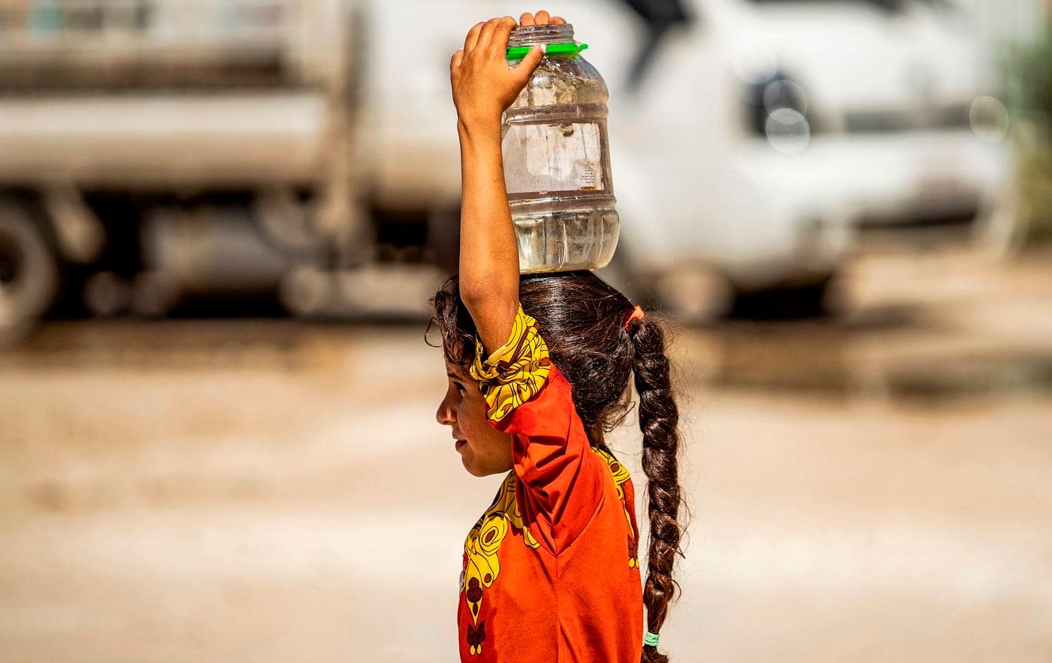 A girl brings water back to a camp for the displaced in Syria's northeastern city of Hasakah on August 24, 2020. Photo: Delil Souleiman/AFP