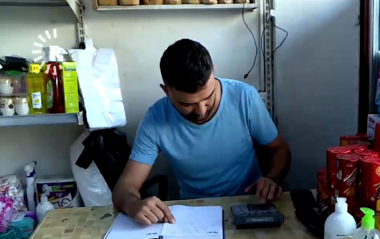 Hawar Aber, a store owner in Duhok, goes through his books. Many of his customers are unable to pay and ask for credit as poverty rates on increasing in the Kurdistan Region. Photo: Rudaw