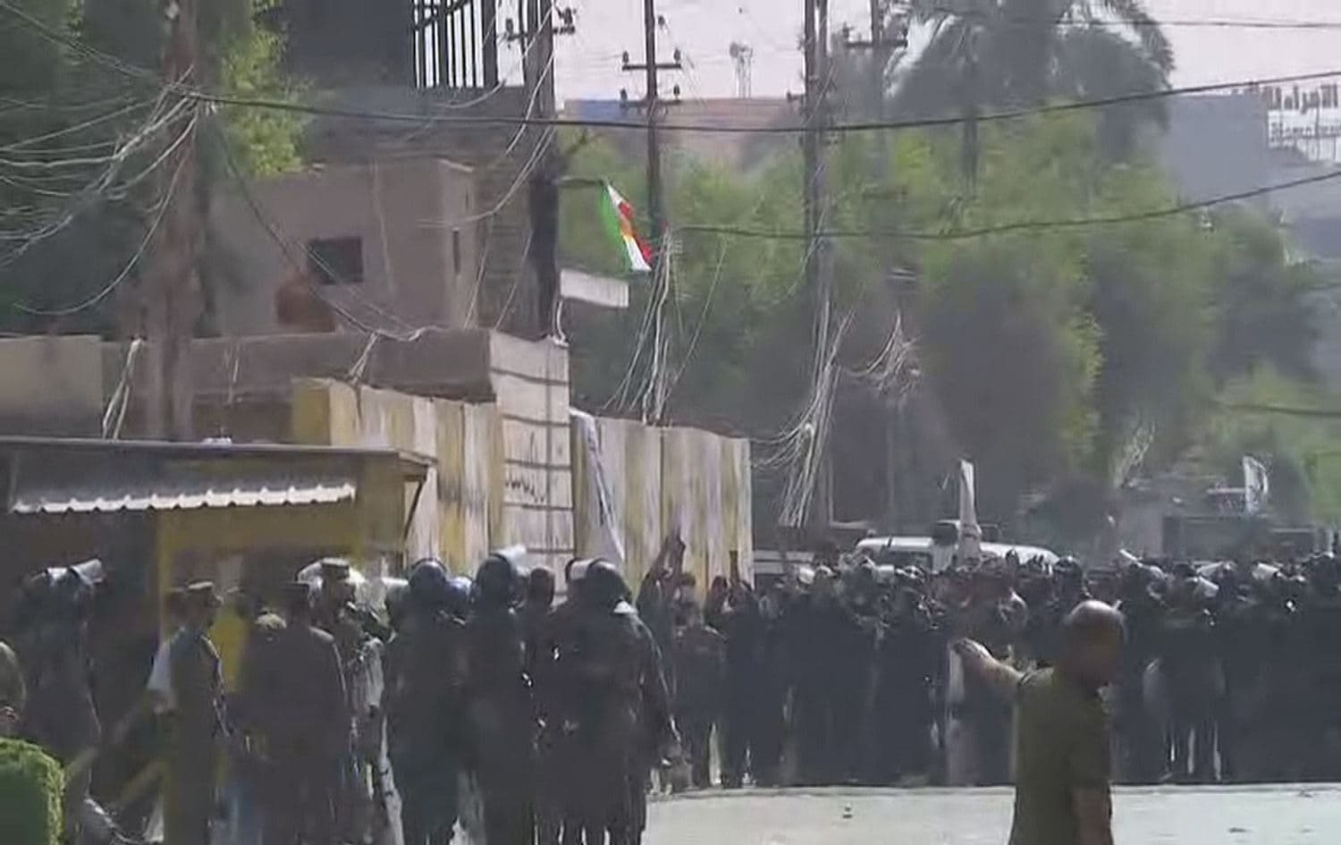 A protester burns a Kurdistan Region flag on the walls of the KDP office in Baghdad on October 17, 2020. Photo: Rudaw 