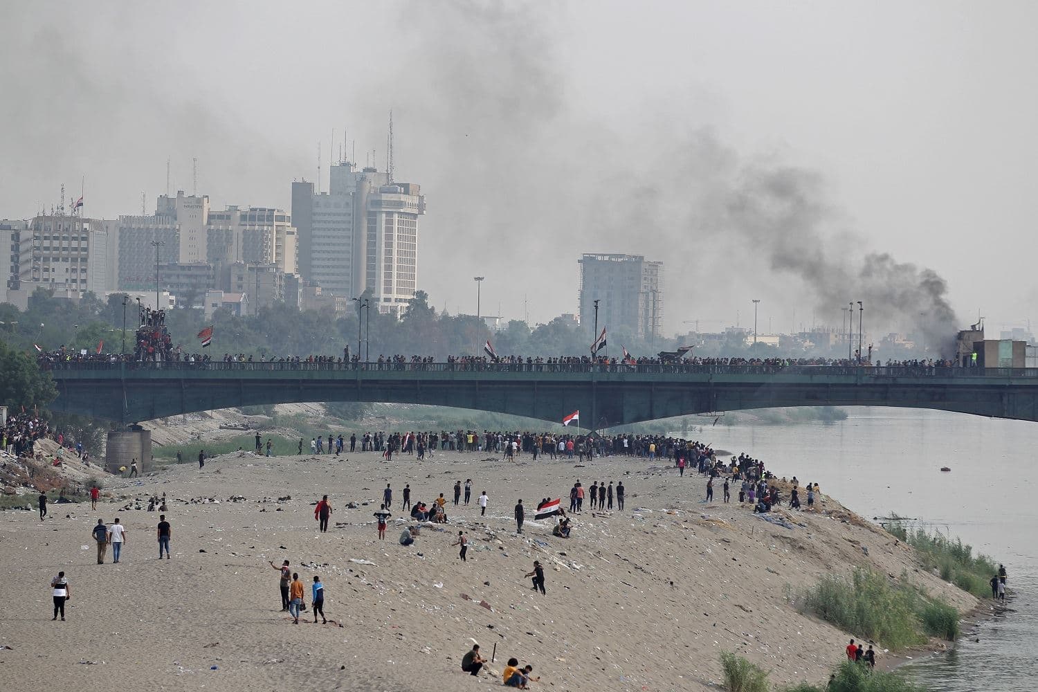 Iraqi protesters clash with security forces following a demonstration on al-Jumhuriya bridge in the capital Baghdad on October 25, 2020, marking the first anniversary of a mass anti-government movement. Photo: Ahmad al-Rubaye / AFP