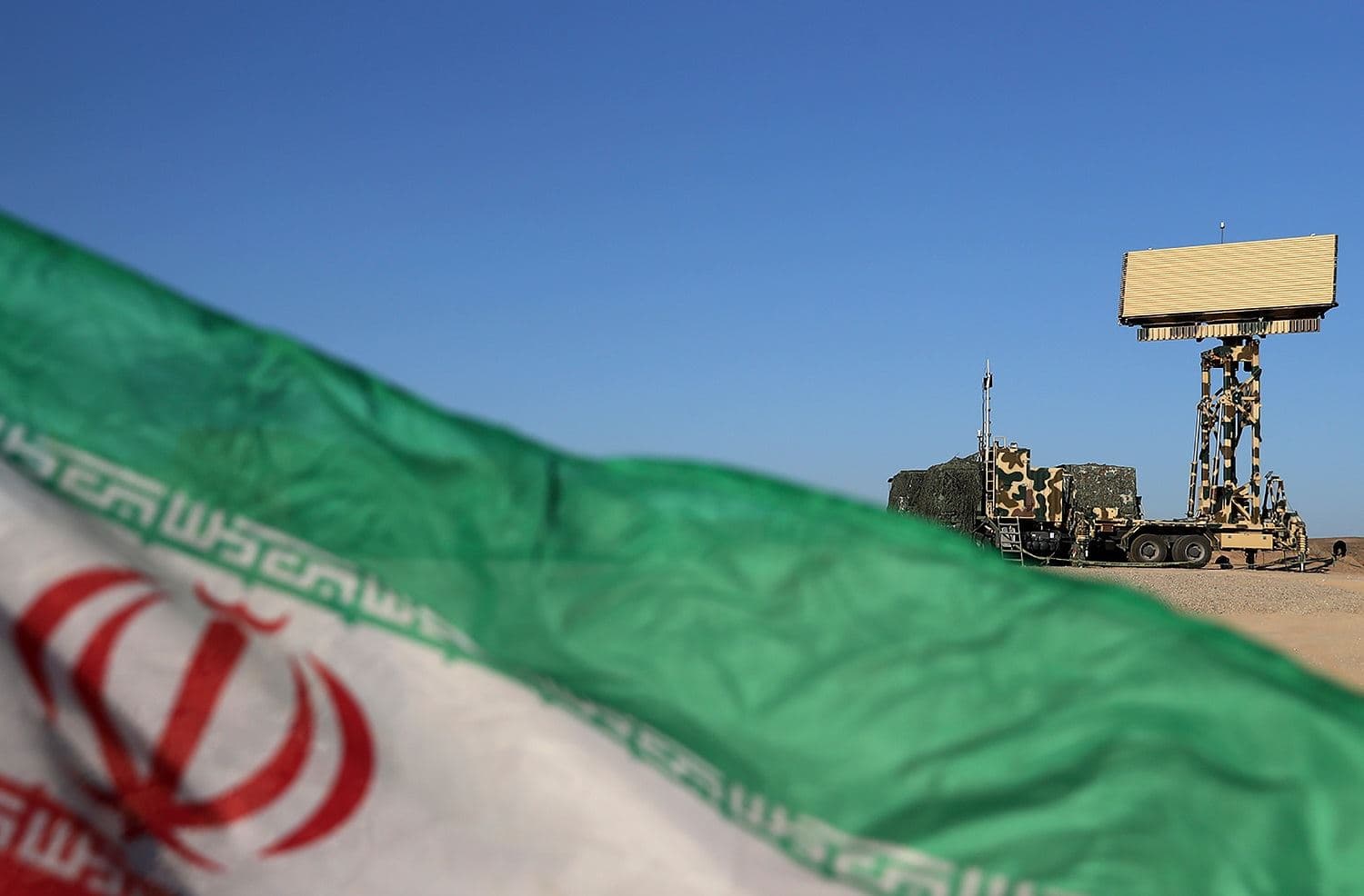 A handout photo made available by the Iranian Army office on October 21, 2020, shows a national flag in front of an Iranian radar system system during the first day of the air defense exercise of 'Aseman Velayat 99', in an unidentified location in Iran. Photo: Iranian Army office / AFP