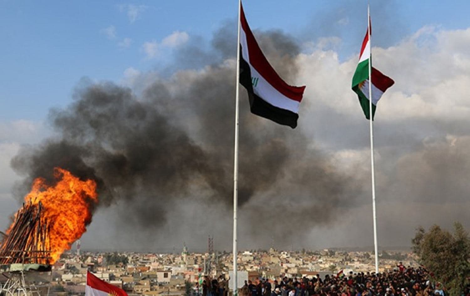 Kurdish and Iraqi flags sway in the wind as a bonfire burns during the Nowruz spring festival celebrations in Kirkuk, north of Baghdad. Photo: Marwan Ibrahim / AFP