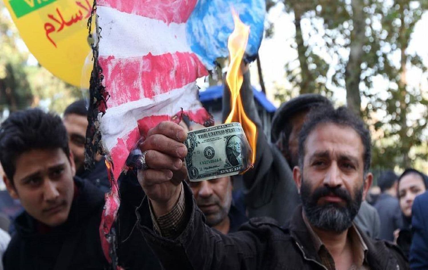An Iranian protester burns a US dollar banknote during a demonstration outside the former US embassy in Tehran on November 4, 2018. Photo: Atta Kenare/AFP