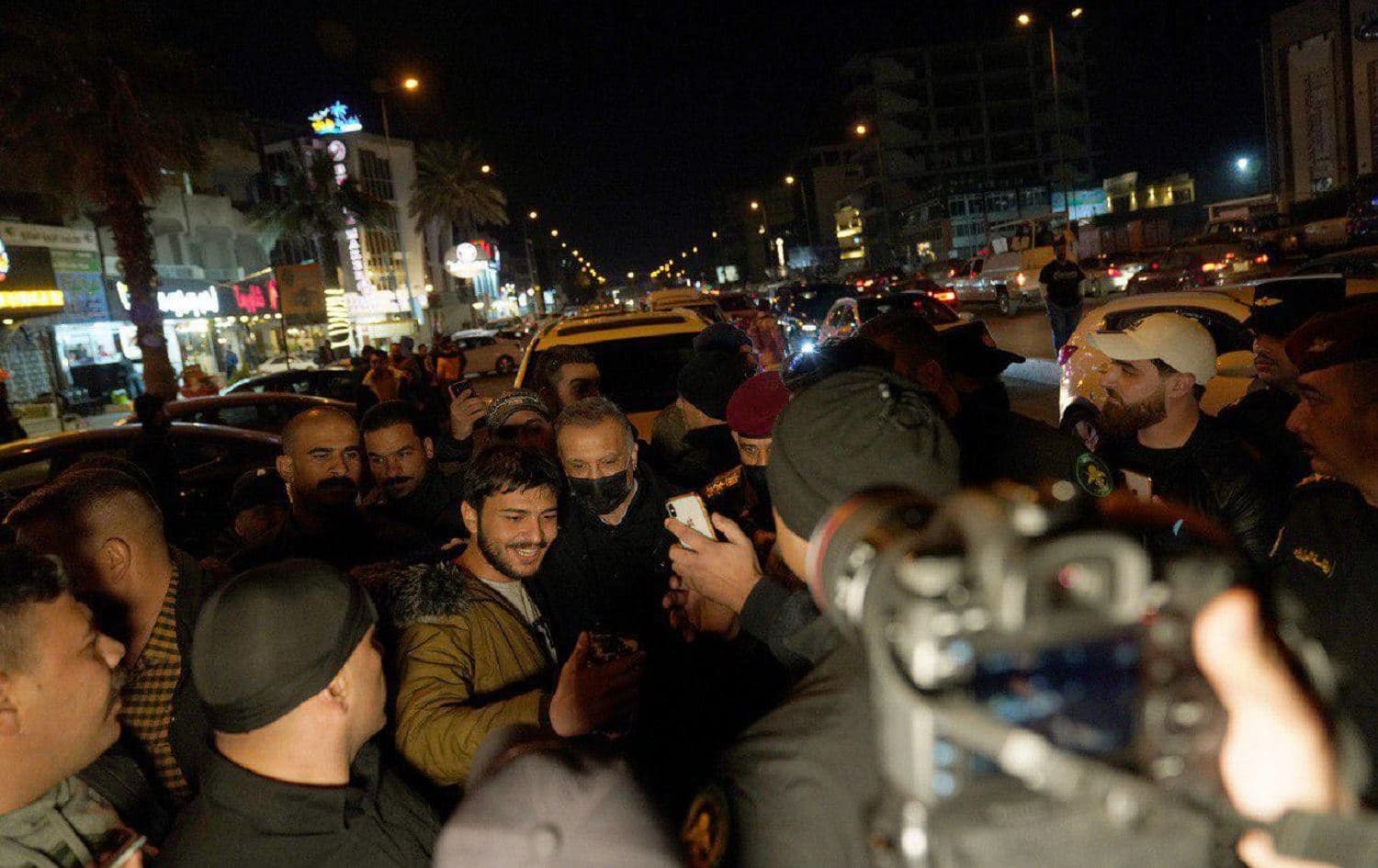 Iraqi Prime Minister Mustafa al-Kadhimi poses for a photograph with an Iraqi man on the streets of Baghdad on December 25, 2020. Photo: handout/PM office