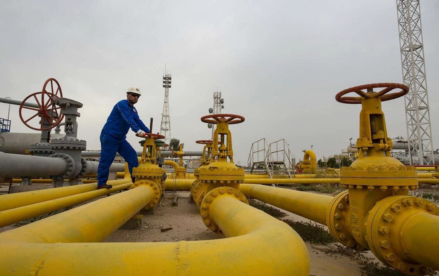 An employee turns a valve at the Nahr Bin Omar natural gas field, north of the Basra, on April 21, 2020. File photo: Hussein Faleh/AFP 