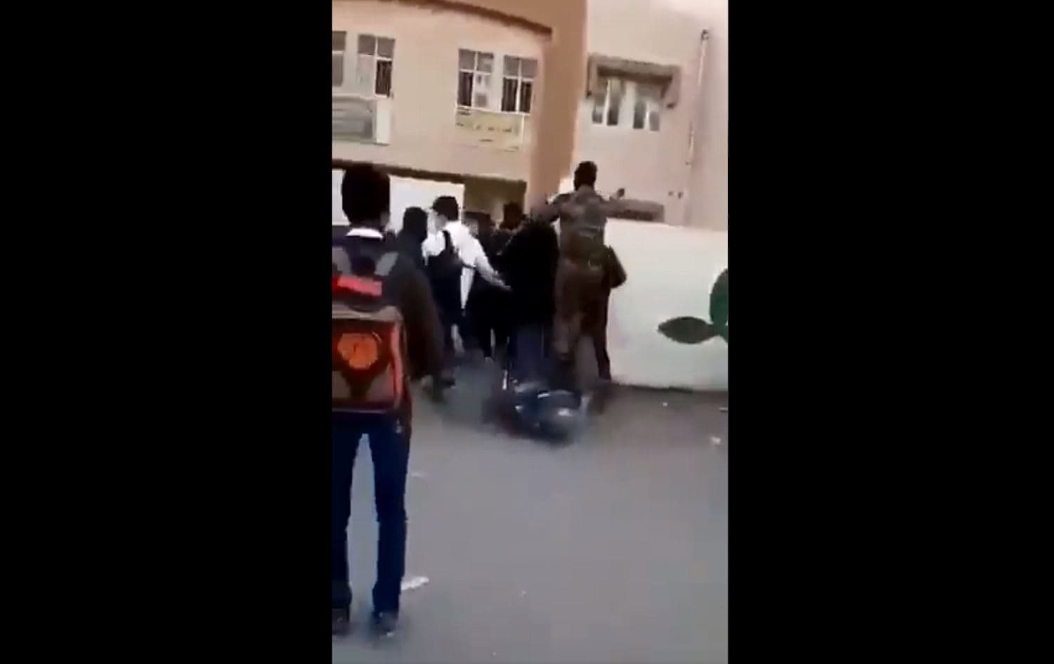 Security force members run into the Central Secondary School in Nasiriyah on January 12, 2021. Photo via Iraqi Observatory for Human Rights video posted to Twitter