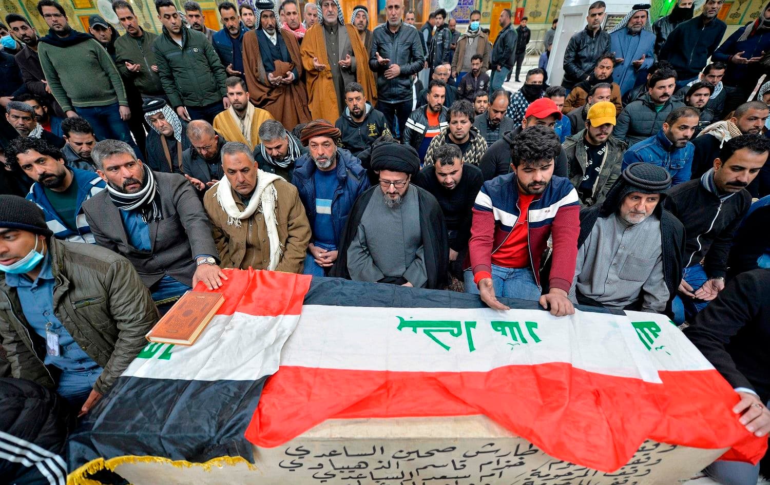 Iraqi mourners pray over the coffin of a victim who was killed in a twin suicide bombing in central Baghdad, during a funeral in the holy city of Najaf on January 21, 2021. Photo: Ali Najafi/AFP