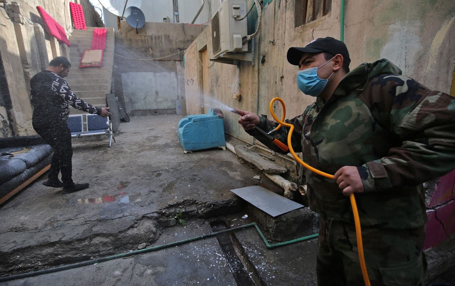 Members of the Iraqi civil defence disinfect an alley next to a local TV station in Baghdad on February 3, 2020. Photo: Ahmad al-Rubaye/AFP