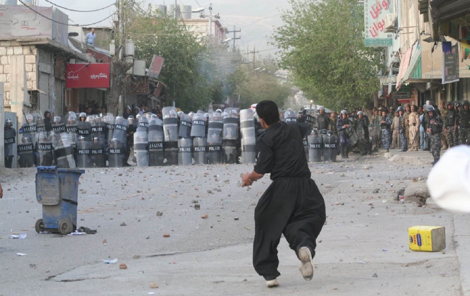 A protester throws a stone at a line of police during demonstrations in Sulaimani in February 2011. Photo: Zmnako Ismael