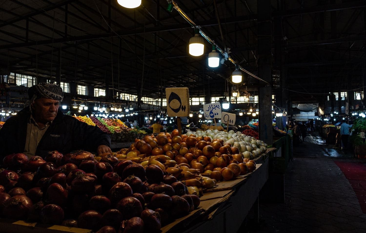 Ibrahim Sulaiman rearranges onions and potatoes he sells at a market in Erbil’s Saidawa neighbourhood on February 11, 2021. Photo: Hannah Lynch / Rudaw
