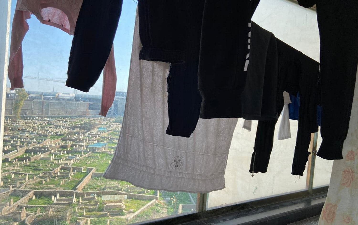 Laundry hangs in a flat facing a graveyard in central Erbil on March 1, 2021. Photo: Holly Johnston / Rudaw