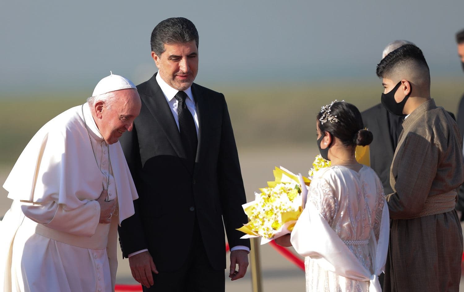 Pope Francis (right) is received in Erbil by Kurdistan Region President Nechirvan Barzani (centre) and children bearing flowers on March 7, 2021. Photo: Bilind T. Abdullah/Rudaw