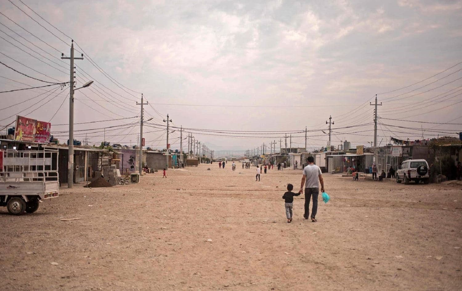 A father and his daughter walk in Arbat camp, Sulaimani province on November 3, 2020. Photo: Florent Vergnes/AFP