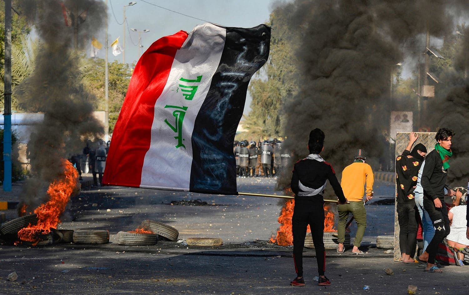 An anti-government protester waves the Iraqi flag during a demonstration in Najaf on March 14, 2021. Photo: Ali Najafi/AFP
