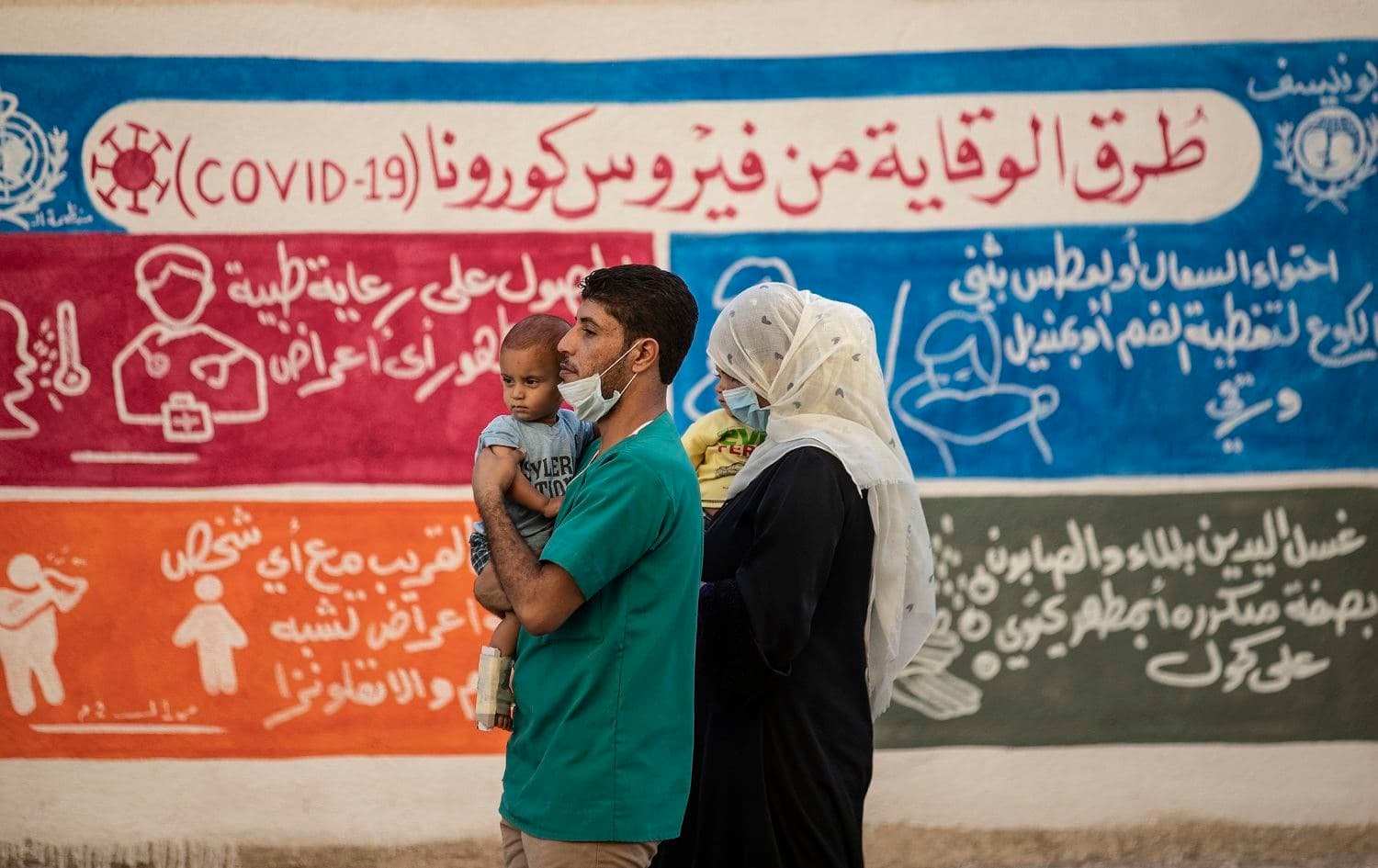 People walk past a mural painted in Qamishli, northeast Syria to raise awareness of the coronavirus pandemic, on August 16, 2020. File photo: Delil Souleiman/AFP