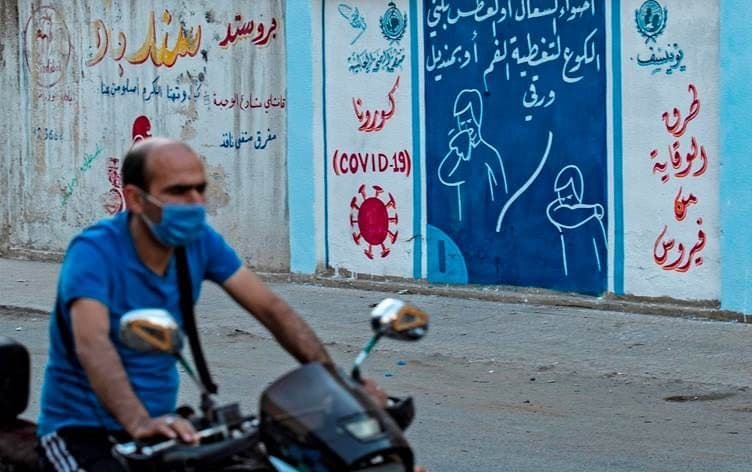 A motorcyclist rides by a mural painted as part of a coronavirus awareness campaign in Qamishli, northeast Syria in August 2020. File photo: Delil Souleiman / AFP