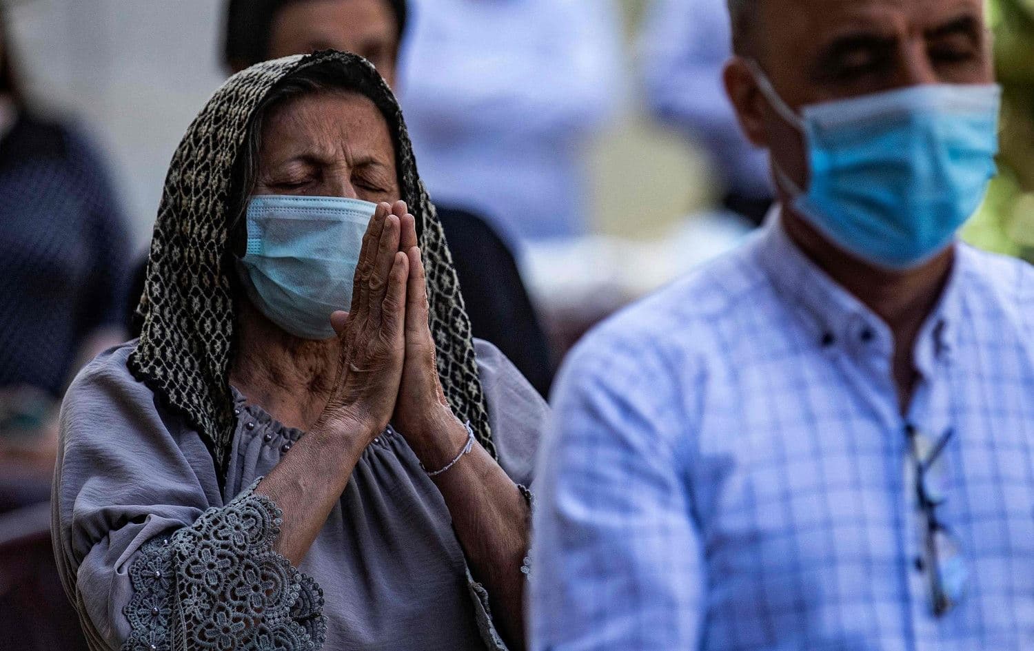 People wearing masks pray during a mass in Qamishli on April 24, 2021, commemorating the Armenian genocide. Photo: Delil Souleiman/AFP