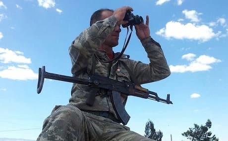 A YPG fighter scans the area with binoculars. Photo: Flickr