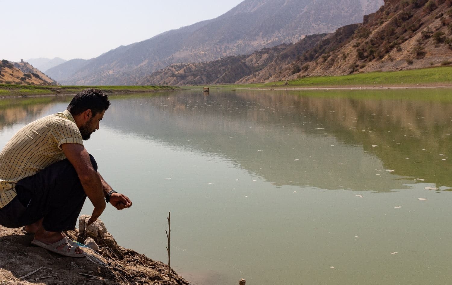 Fisherman Hunar Mohammed Abdullah checks his lines in the Sirwan River on September 20, 2020. Photo: Hannah Lynch/Rudaw
