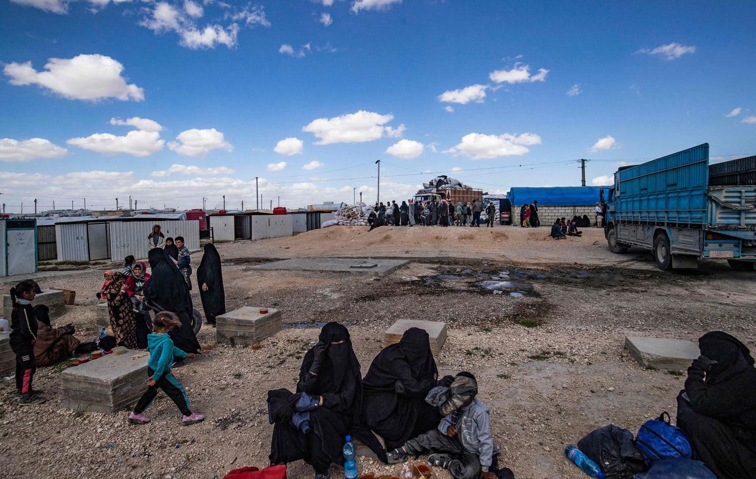 Syrian women and children await departure, part of a group of families released from al-Hol camp in Hasaka, northeast Syria, on March 18, 2021. Photo: Delil Souleiman/AFP