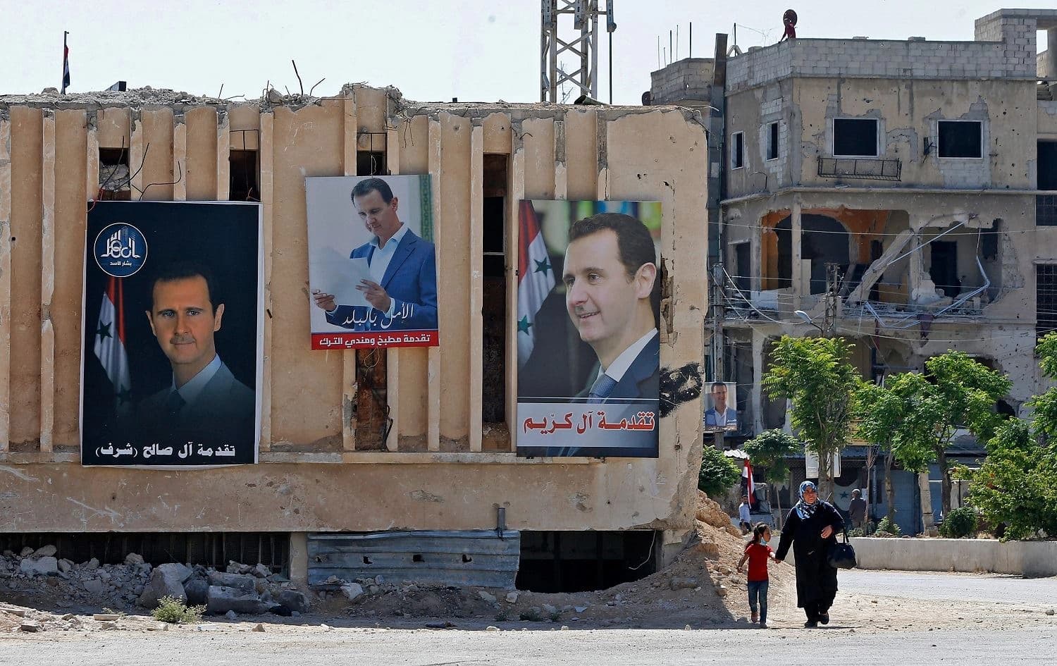 Portraits of Syrian President Bashar al-Assad are hung on buildings at a polling station set up for presidential elections in Douma on May 26, 2021. Douma was the site of a chemical weapon attack on April 7, 2018, which the OPCW concluded was likely molecular chlorine. Photo: Louai Beshara/AFP