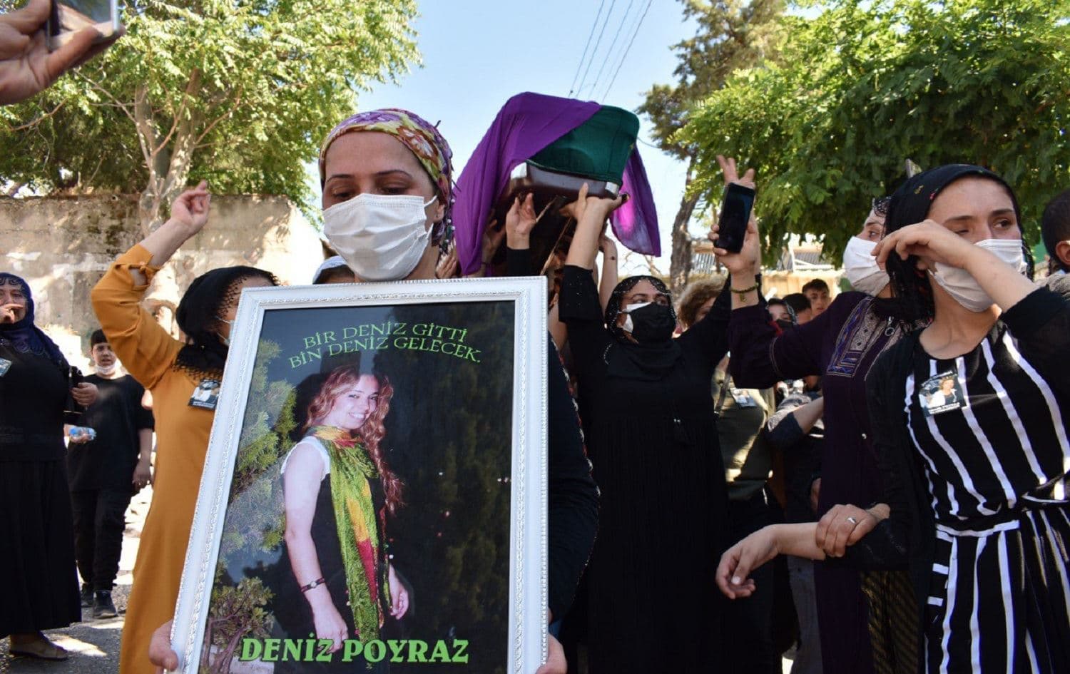 A woman holds a portrait of Deniz Poyraz during her funeral on June 18, 2021. Photo: HDP